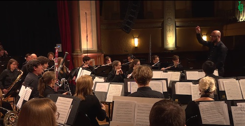 Side view of performance on stage. Curtesy of https://brassbanned.com/